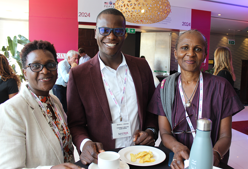 Three people smiling together during a tea break