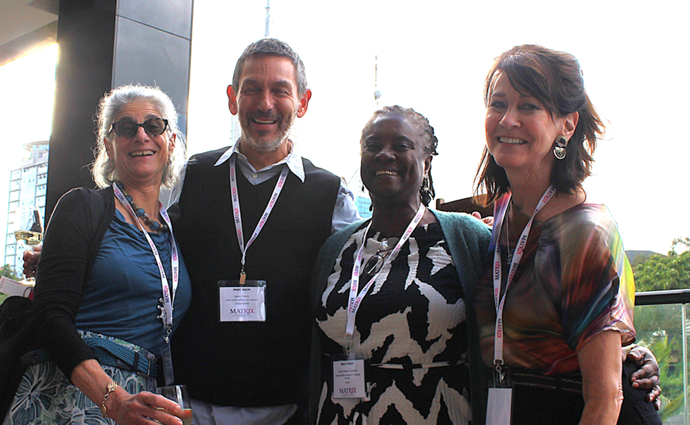 Four people smiling together during a meeting break